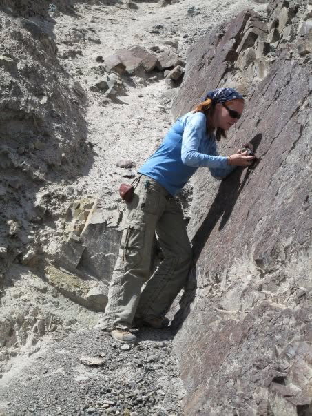Wendy examining a rock outcrop during field research.